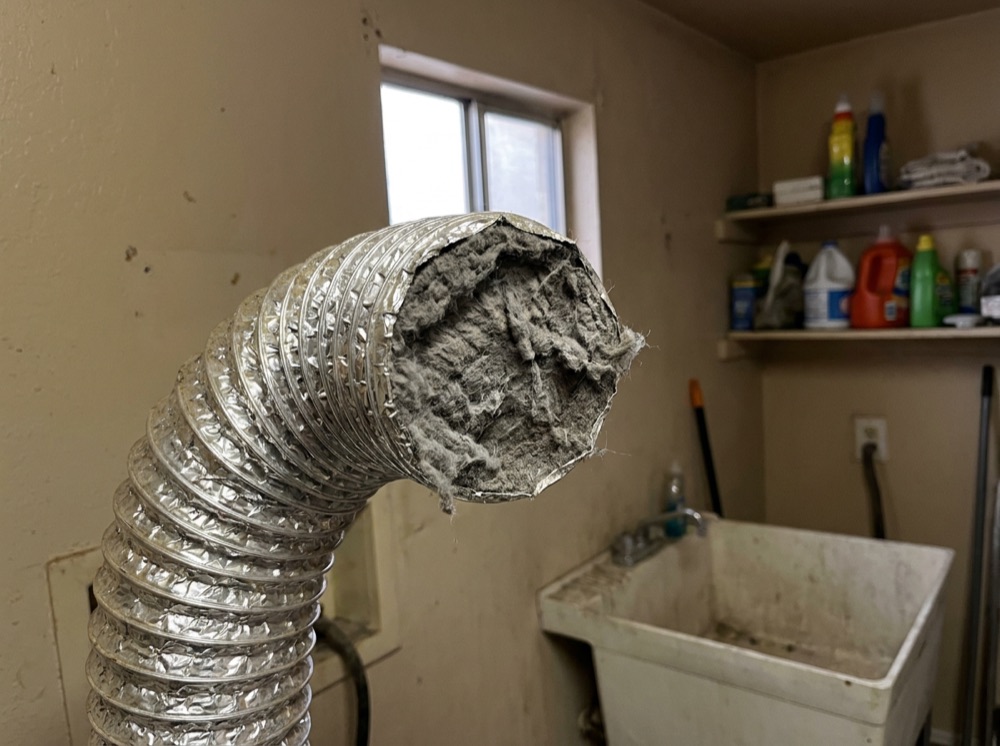 Vent packed with years of compacted lint